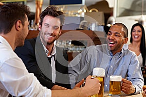 Young businessmen drinking beer at pub