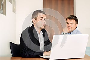 Young Businessmen Looking at Laptop on Table