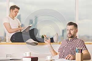 Young businessmen reading book and doing paperwork