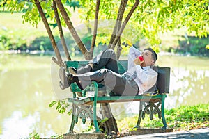 Young businessmen are resting on chairs and eating apples after