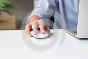 Young businessmen are using a mouse on a white desk to work at home. Close up of the hand