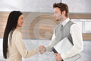 Young businesspeople greeting each other smiling