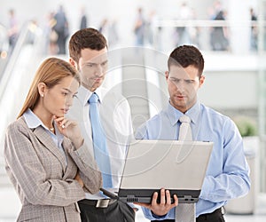 Young businesspeople looking at laptop screen