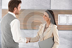 Young businesspeople shaking hands smiling