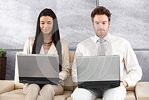 Young businesspeople sitting in office lobby