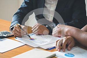 Young businessteam work on statistics and business graphs, discussing the charts and graphs showing the results at meeting,