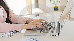 Young businesswoman analyzes cost graphs on desk in conference room with laptop