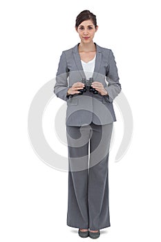 Young businesswoman with binoculars