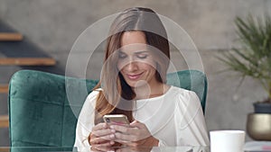 Young businesswoman browsing internet on smartphone. Happy girl looking phone