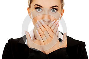 Young businesswoman covering with hand her mouth. Speak no evil concept