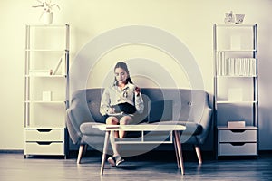 Young businesswoman with cup of coffee working on laptop with too much work in office. Secretary girl.