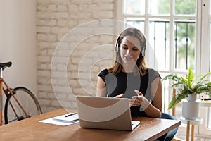 Young businesswoman discussing project details with clients via video call.