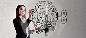 Young businesswoman drawing creative brain sketch with wind-up mechanism on concrete wall background. Intelligence, strategy,