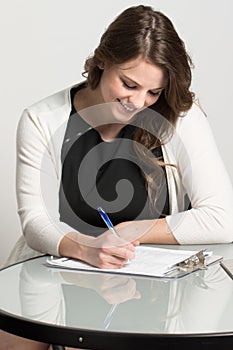 Young businesswoman filling out an application.