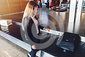 Young businesswoman getting her luggage from baggage claim at airport