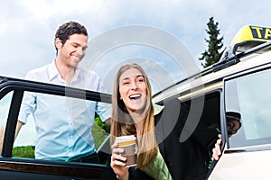 Young businesswoman getting out of taxi