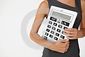 Young businesswoman with giant calculator