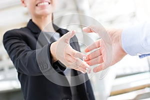 Young businesswoman going to make handshake with a businessman