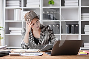 Young businesswoman has problems with her work in the office Feeling stressed and unhappy, showing a serious expression