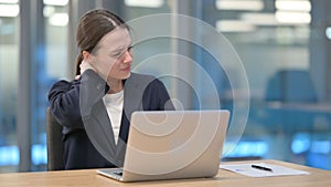 Young Businesswoman having Neck Pain while Typing on Laptop