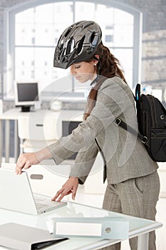 Young businesswoman leaving office by bike