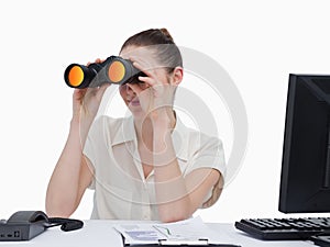 Young businesswoman looking through binoculars