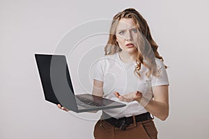 Young businesswoman at modern home office desk with laptop impressed by the bill to pay, revealed online affair, e-mail
