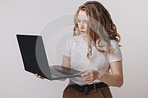 Young businesswoman at modern home office desk with laptop impressed by the bill to pay, revealed online affair, e-mail