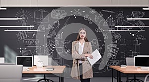 Young businesswoman in modern office with creative business strategy sketch drawn on a wall