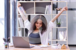 Young businesswoman office worker stretching lazily and forth relieves pain at office table workplace, feeling overworked photo
