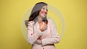 Young businesswoman in pink suit on yellow background