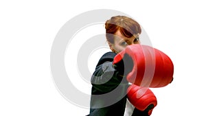 Young businesswoman punching with boxing gloves