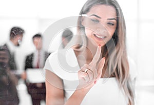 Young businesswoman pushing on glass Board.