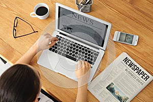 Young businesswoman reading news on laptop screen in office