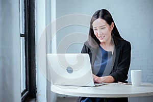 Young businesswoman rejoicing after sales surpass their target Check results from laptop photo