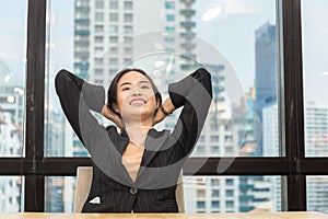 Young businesswoman relaxing at her desk in modern office