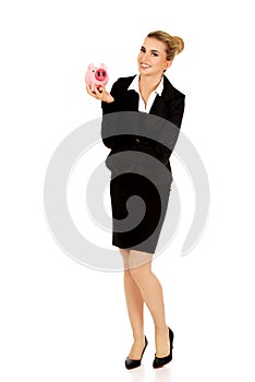 Young businesswoman saving money in piggybank