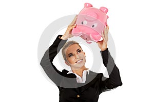 Young businesswoman saving money in piggybank
