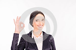 Young businesswoman showing gesture `OK` and smiling