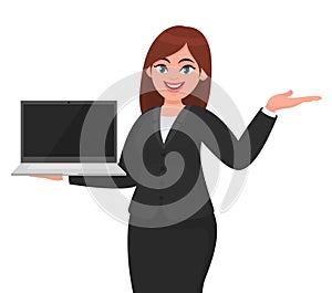 Young businesswoman showing a new brand laptop and presenting hand gesture to copy space. Person holding portable computer.
