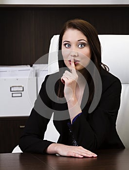 Young businesswoman showing quiet sign