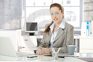 Young businesswoman sitting in bright office