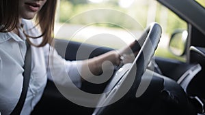 Young businesswoman sitting into the car, speaking on the phone and flirting