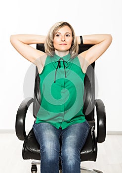 Young businesswoman sitting on chair doing fitness exercise at workplace