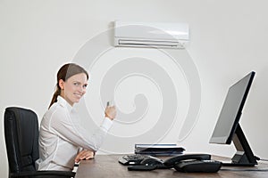 Businesswoman Using Air Conditioner In Office