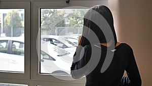 Young businesswoman sitting at desk in office busy on phone