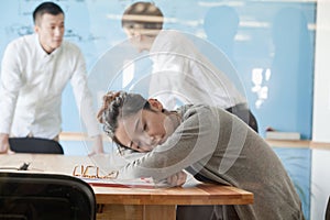 Young businesswoman sleeping during meeting