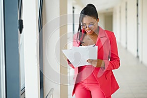 Young Businesswoman Standing In Corridor Of Modern Office Building