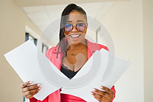 Young Businesswoman Standing In Corridor Of Modern Office Building