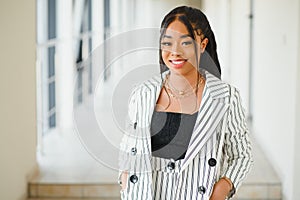 Young Businesswoman Standing In Corridor Of Modern Office Building